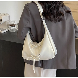 Chic off-white crescent underarm bag with bow tie ribbons and stylish wide shoulder strap