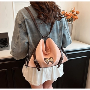 Detail of pink PU leather triangle backpack featuring a gold sequin butterfly motif