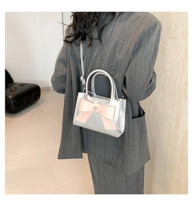 Sac en cuir argenté avec nœud rose, présenté de dos porté par un mannequin