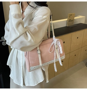 Detail of pink PU leather handbag with lace-up ribbon and vintage floral fabric panels