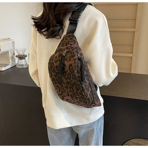 Detail of leopard print crossbody bag featuring double zippers and durable canvas texture