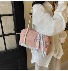 Detail of pink PU shoulder bag with floral patchwork and lace bow decoration