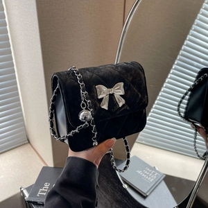 Quilted black velvet shoulder bag with silver bow and chain strap for spring 2024