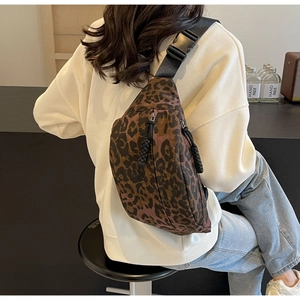 Detail of leopard print crossbody bag showing adjustable strap and buckle on model