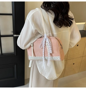Detailed view of a pink PU handbag featuring a lace bow and floral fabric trim detail