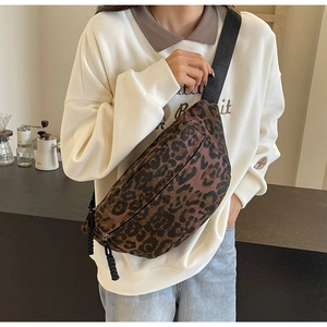 Detail of leopard print crossbody bag with dual zippers and adjustable nylon shoulder strap