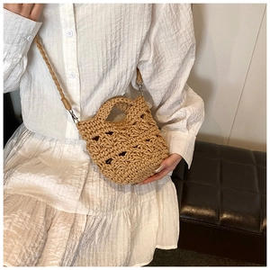 Detail showing hand-woven knit fabric texture and silver metal clasp of the beige crossbody bag