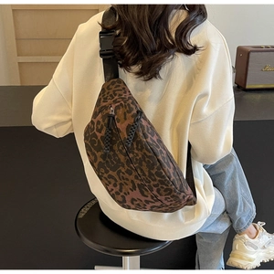 Detail shot of leopard print crossbody bag with black nylon strap and woven rope zipper