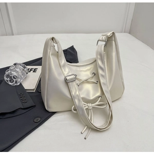 Chic cream PU leather shoulder bag with cross-lace and bow detail in a modern layout