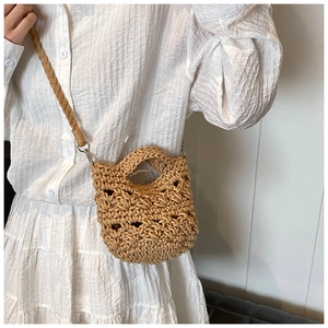 Detailed close-up of oatmeal knit crossbody bag with hollow crochet texture and metal clasps