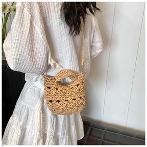 Detail of hand-woven hollow knit texture and dual-strap design on a beige shoulder bag