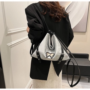 Detail of silver faux leather shoulder bag with butterfly embroidery and adjustable strap