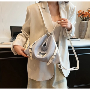 Detail of lavender PU leather crossbody bag featuring a delicate butterfly patch and buckles
