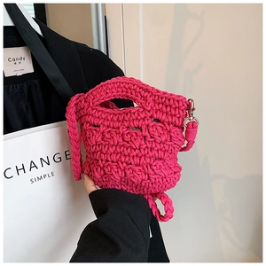 Mini magenta knitted crossbody bag with textured honeycomb pattern and shoulder strap