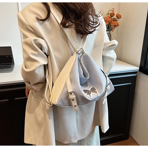 Detail of color-block PU leather bag with butterfly patch and silver metal buckle