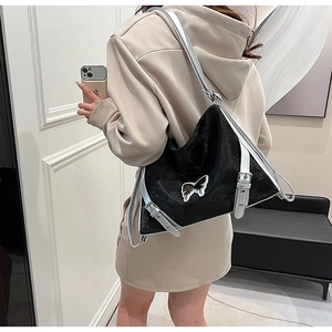 Detailed view of black PU shoulder bag with silver butterfly emblem and metal buckles