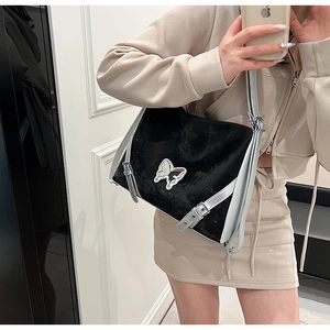 Detail of black velvet shoulder bag with butterfly patch and adjustable silver leather strap