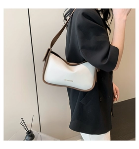 Detail der minimalistischen PU-Leder Hobo-Tasche mit Logo auf schwarzem Blazer