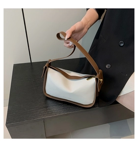 Detail der minimalistischen PU-Leder Umhängetasche in Creme mit braunem Rand
