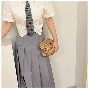 Detail of white swallowtail shirt paired with grey pleated skirt and striped tie