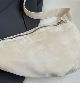Close-up of creamy white velvet crossbody bag showing the soft texture and zipper detail