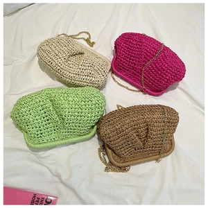 Flat lay of colorful woven straw bags in beige, pink, green and brown with gold chains