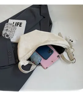 Detail showing the large interior capacity of this cream crescent bag with daily essentials