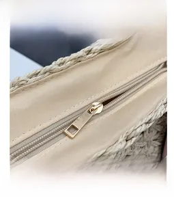 Detailed macro view of high-quality golden metal zipper and woven texture on straw beach bag