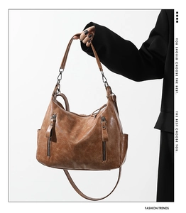 Detail of vintage brown leather tote bag with vertical zippers and soft textured finish