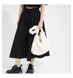 Detailed close-up of the white bubble textured fabric and ruched handle of the casual tote bag