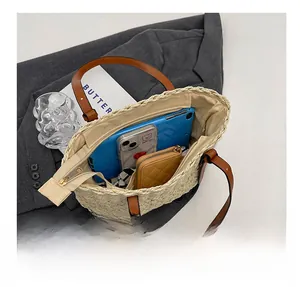 Spacious interior of beige woven straw tote bag showing tablet, phone, and zipper detail