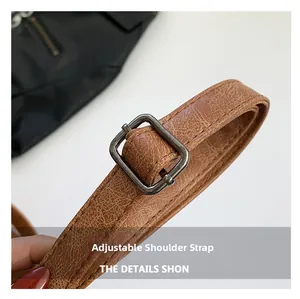 Close-up of adjustable brown synthetic leather strap with fine litchi texture and metal buckle