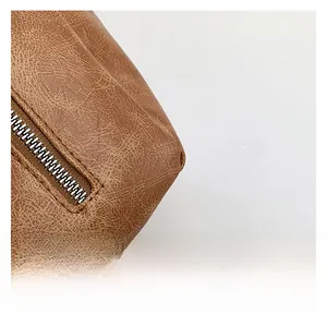 Detail of retro brown leather handbag with zipper and lychee texture stitching