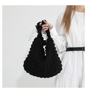 Close-up of black popcorn textured cloud bag with unique 3D wavy fabric detail