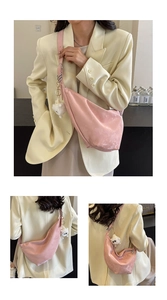 Detail view of pink crescent bag with metal hardware and cute plush charm pendant