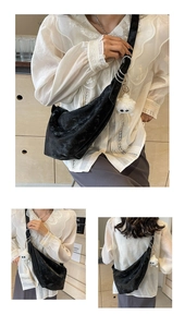 Detail of black textured crescent bag with silver rings and plush doll accessory