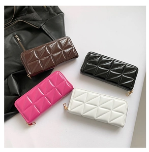 Flat lay of four colorful patent leather crossbody bags with geometric quilting