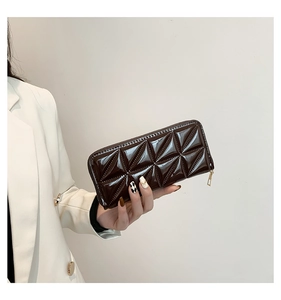 Detail view of dark chocolate patent leather wallet with textured quilted pattern