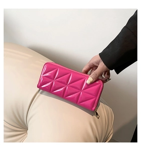 Detail of rose pink quilted leather wallet featuring secure gold zipper and chic rhombic pattern