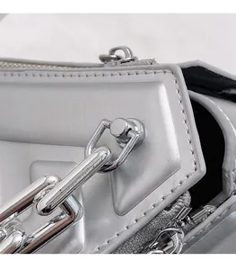Detailed macro view of silver metallic PU handbag featuring thick chain and metal zipper