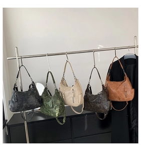 Detail view of vintage hobo bags hanging in black, green, beige, coffee, and brown colors