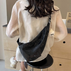 Black large half-moon crossbody bag with silver rings and plush monster charm