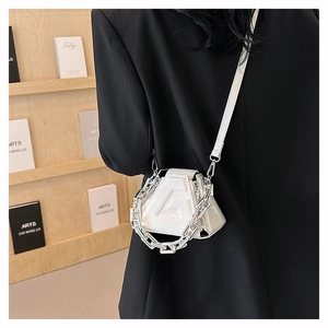 Detailed view of white geometric handbag with embossed G logo and chunky silver chain