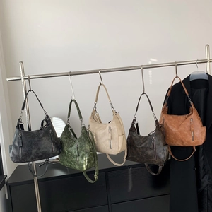 Vintage shoulder bags in five colors including black, green, and brown on a metal rack