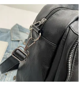 Detail of high-gloss silver hardware and litchi texture leather on black messenger bag