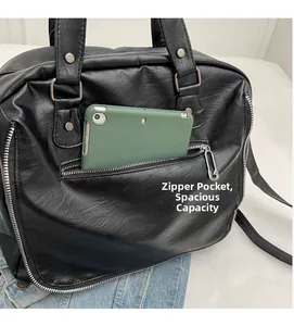 Detail of front zipper pocket on black leather tote with pin-style puller and tablet space