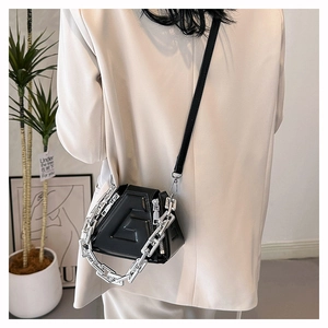 Detail view of black PU leather bag with G-shaped texture and silver chain strap