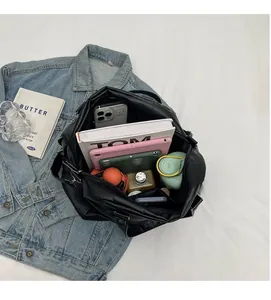 Interior view of large black messenger bag showing spacious capacity for tablets and books
