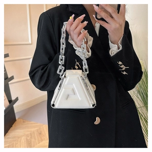 Detail view of ivory white triangular PU handbag featuring embossed F letter and silver chain