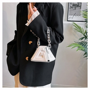 Detail of white PU leather handbag featuring G-letter embossing and chunky silver chain handle